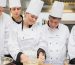 Pastry chef showing students how to prepare dough in kitchen